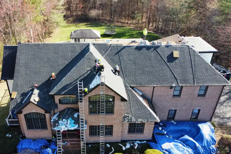 Residential roof replacement, service in progress after learning the answer to "How much to replace a roof?" in Manchester, NH